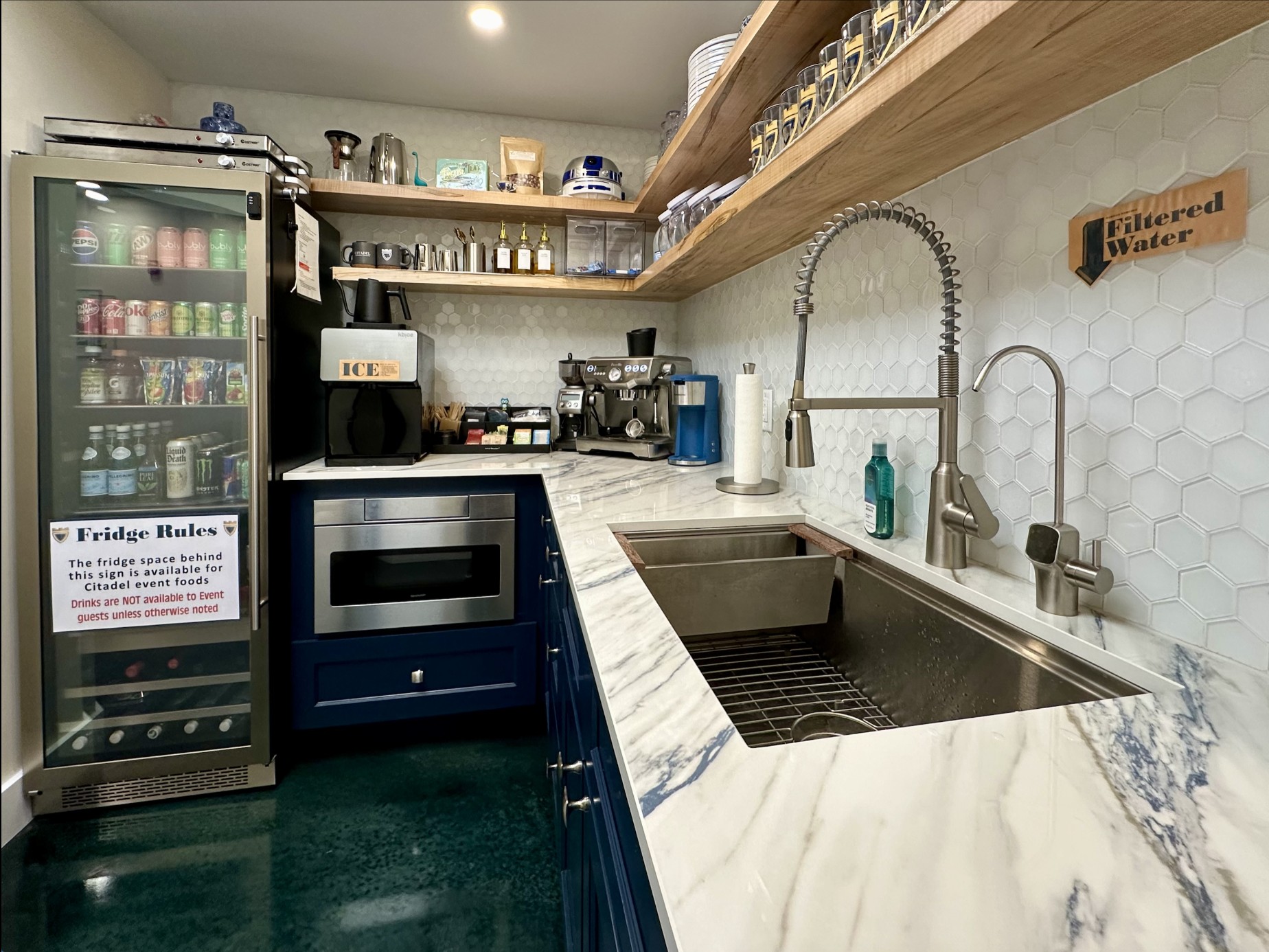The Citadel kitchen area with marble counters, sink, ice maker, espresso machine, and beverage fridge